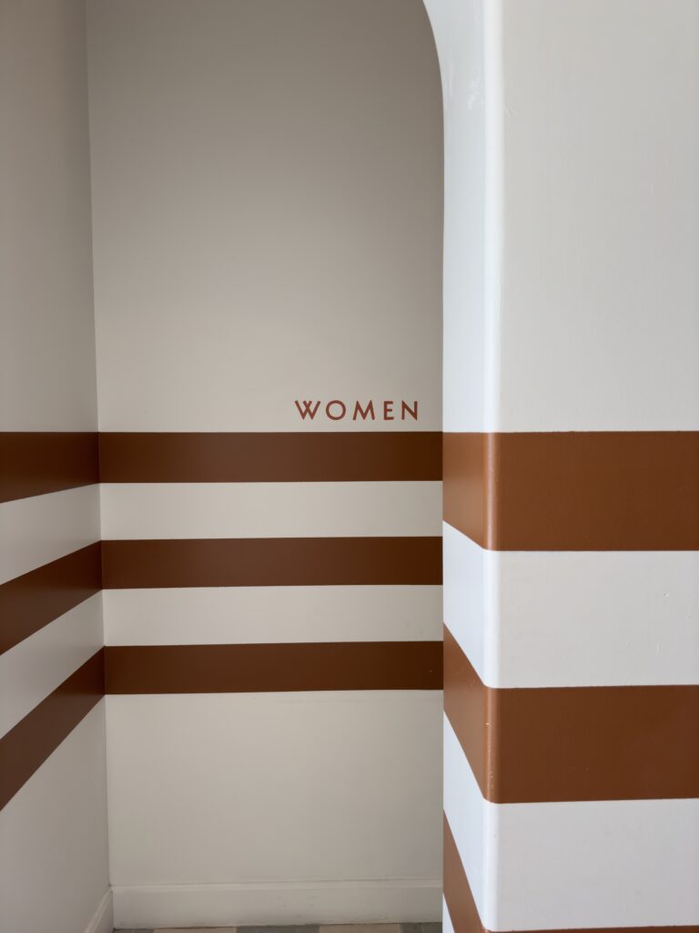 photo of a wall with stripe that says women